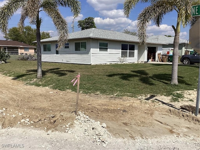 single story home with roof with shingles and a front lawn