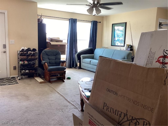 carpeted living area with a ceiling fan