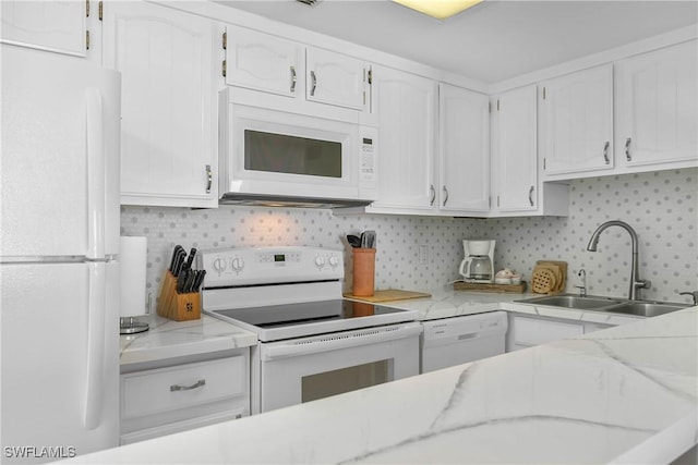 kitchen featuring white appliances, backsplash, a sink, and white cabinets