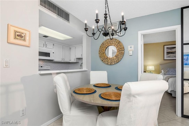 dining area with a chandelier, visible vents, and light tile patterned floors