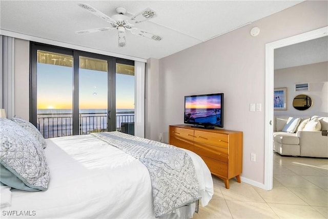 tiled bedroom featuring access to outside, floor to ceiling windows, baseboards, and ceiling fan