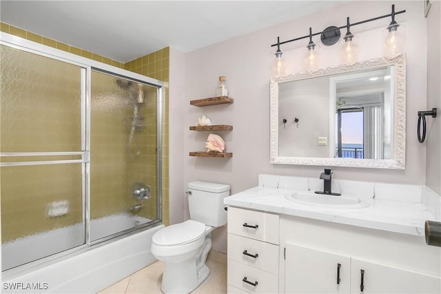 full bath featuring tile patterned flooring, enclosed tub / shower combo, vanity, and toilet