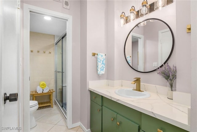 bathroom featuring vanity, a shower stall, toilet, and tile patterned floors