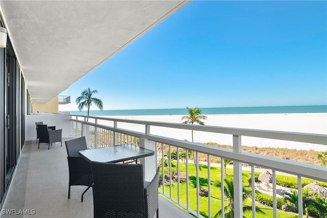 balcony with a water view and a view of the beach