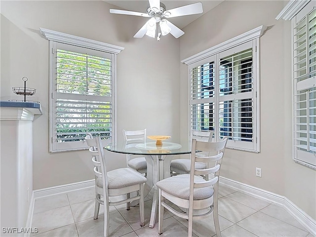 dining area featuring light tile patterned floors, baseboards, a healthy amount of sunlight, and ceiling fan