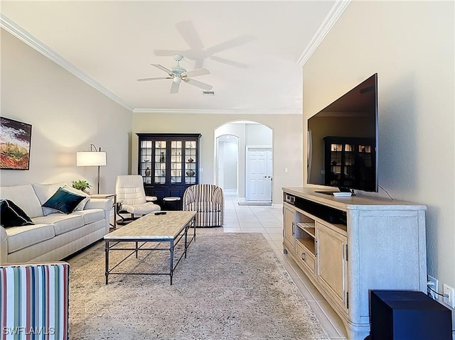 living room with crown molding, light tile patterned floors, arched walkways, and ceiling fan