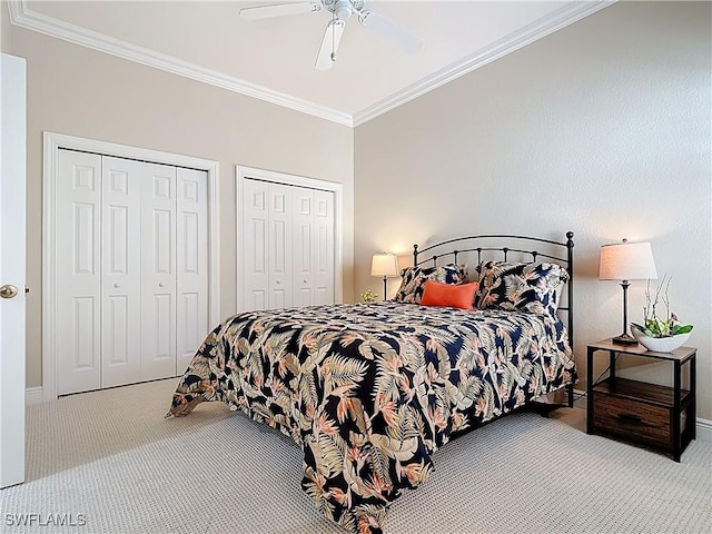 bedroom featuring a ceiling fan, multiple closets, carpet, and crown molding