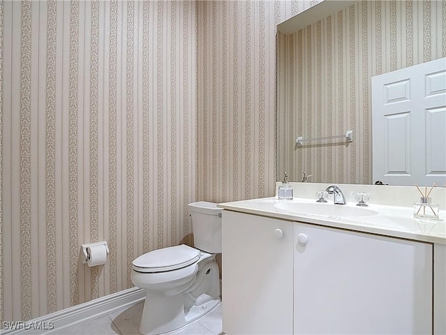 bathroom with tile patterned flooring, toilet, wallpapered walls, and vanity