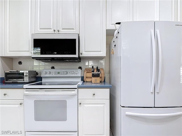 kitchen featuring a toaster, backsplash, white appliances, and white cabinetry