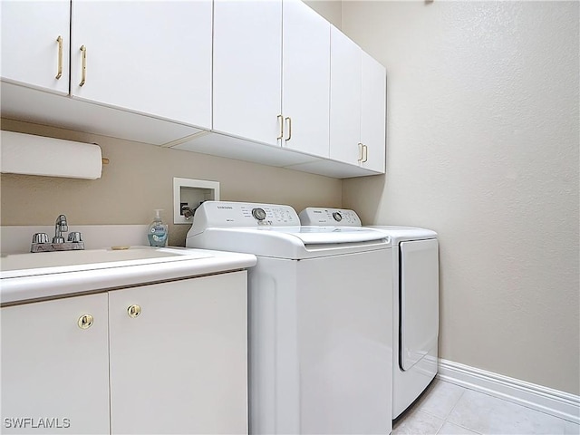 clothes washing area with baseboards, separate washer and dryer, light tile patterned flooring, cabinet space, and a sink