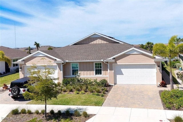 single story home with a garage, board and batten siding, decorative driveway, and roof with shingles