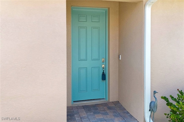 doorway to property featuring stucco siding