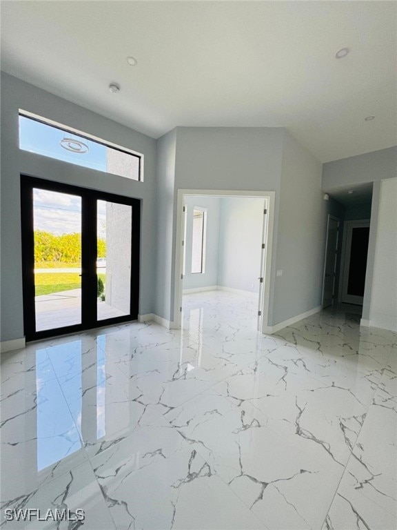 entrance foyer with marble finish floor, baseboards, and french doors