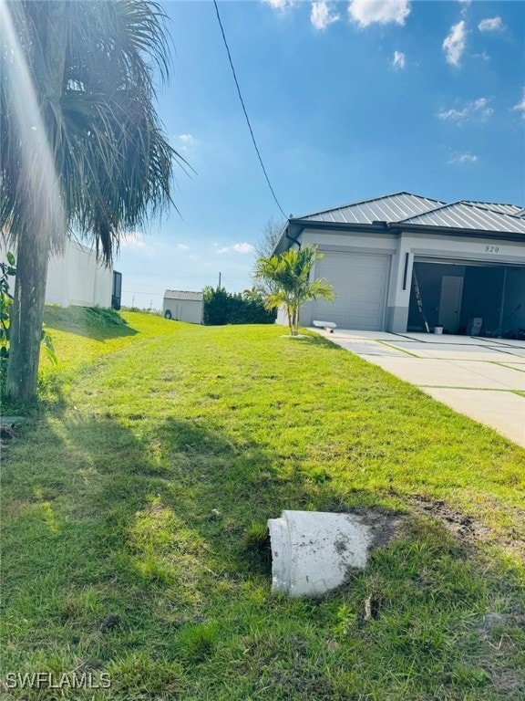 view of yard with an attached garage and concrete driveway