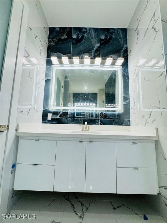 bathroom with marble finish floor and vanity