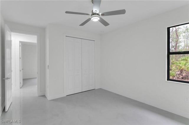 unfurnished bedroom with a closet, a ceiling fan, and concrete flooring