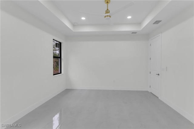 spare room with baseboards, a raised ceiling, visible vents, and recessed lighting