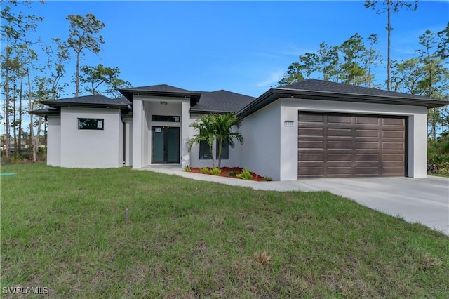 prairie-style house with a garage, driveway, a front yard, and stucco siding