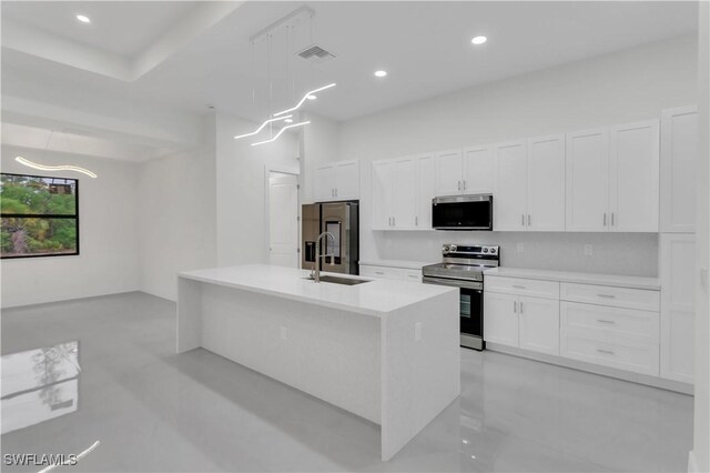 kitchen with a center island with sink, light countertops, appliances with stainless steel finishes, white cabinets, and a sink