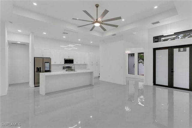 kitchen featuring visible vents, stainless steel appliances, a tray ceiling, and white cabinetry