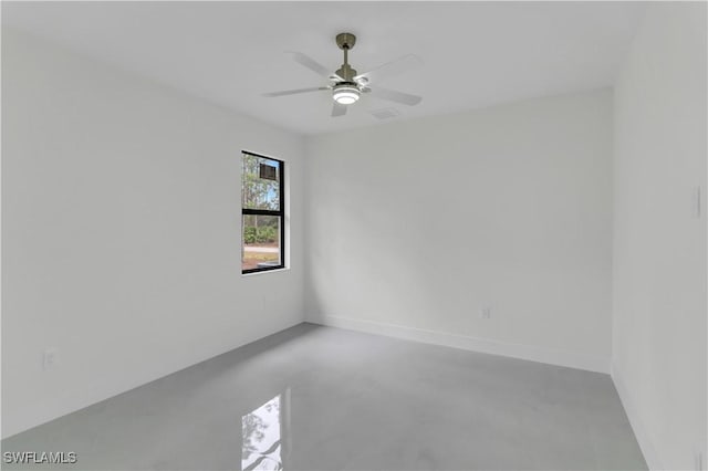 empty room with ceiling fan, concrete floors, and baseboards