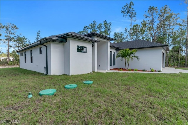 prairie-style house with a front yard and stucco siding