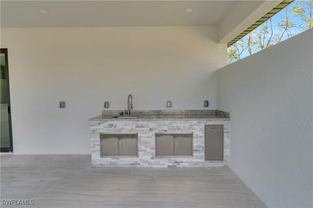 view of patio / terrace featuring exterior kitchen and a sink