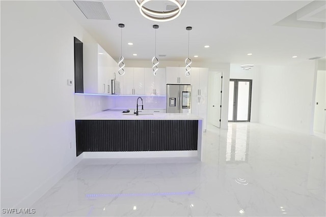 kitchen featuring marble finish floor, stainless steel refrigerator with ice dispenser, visible vents, white cabinetry, and a sink