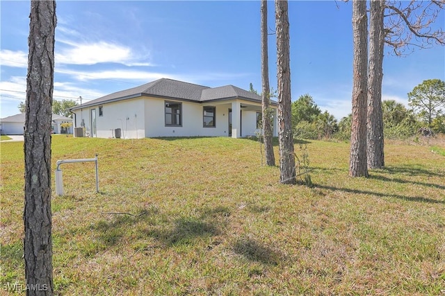 back of property featuring a yard and stucco siding