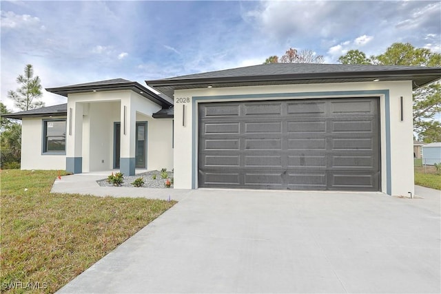 view of front of home featuring driveway, a front yard, an attached garage, and stucco siding