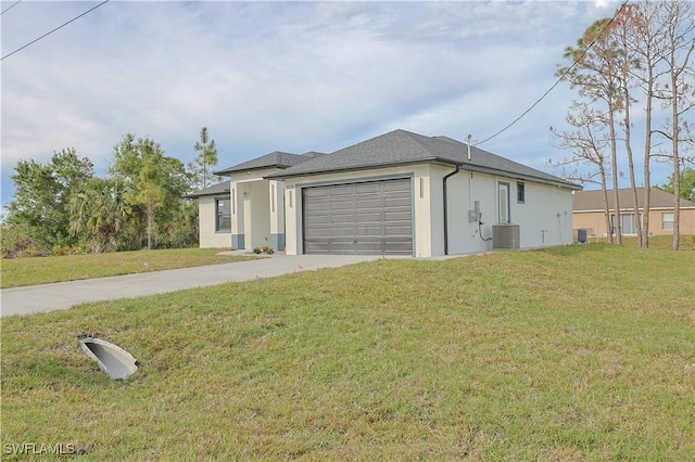 view of front of house featuring an attached garage, central AC, concrete driveway, and a front yard