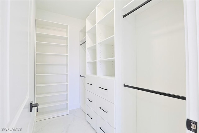 spacious closet featuring marble finish floor