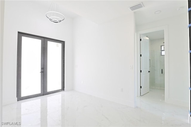 empty room with marble finish floor, french doors, visible vents, and baseboards