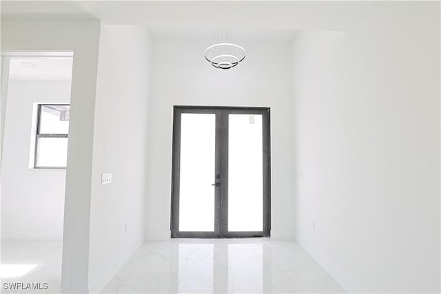 doorway featuring marble finish floor, baseboards, and french doors