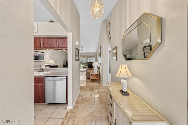 hallway featuring a notable chandelier, a sink, and baseboards
