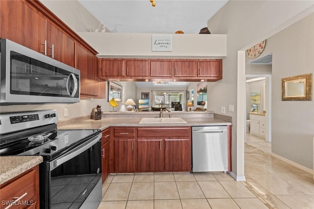 kitchen featuring appliances with stainless steel finishes, light countertops, a sink, and light tile patterned flooring