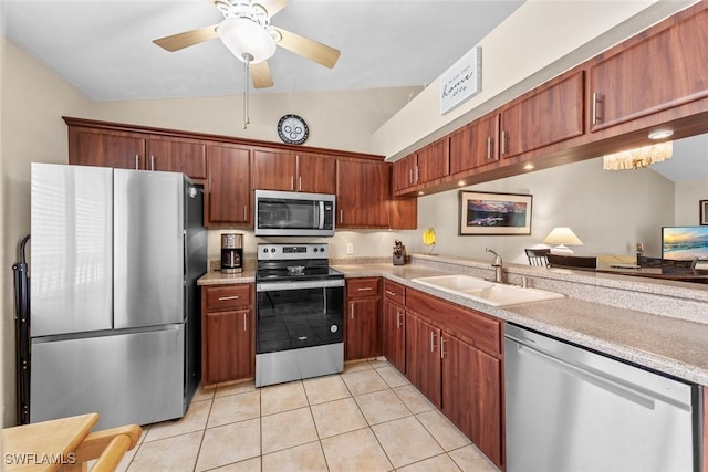 kitchen with light tile patterned floors, stainless steel appliances, light countertops, vaulted ceiling, and a sink
