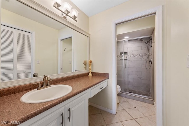 full bath with toilet, a shower stall, vanity, tile patterned flooring, and baseboards
