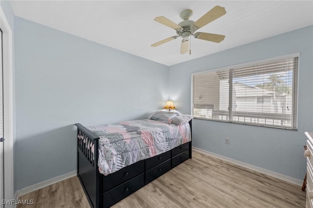 bedroom with wood finished floors, a ceiling fan, and baseboards