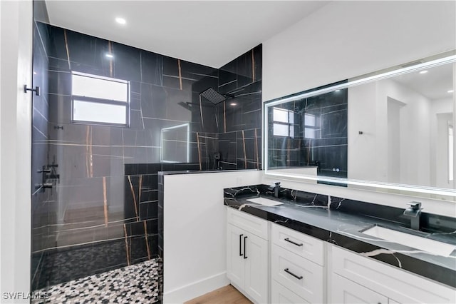 full bathroom featuring a walk in shower, double vanity, and a sink