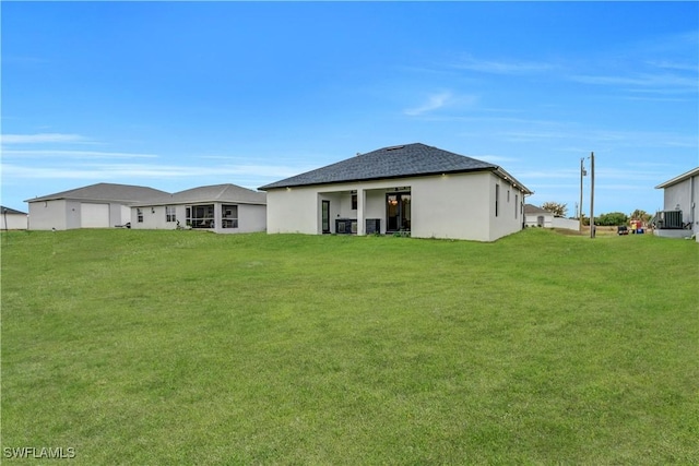 back of house with central AC unit and a lawn