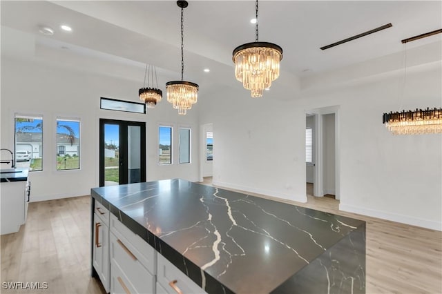 kitchen featuring light wood finished floors, a chandelier, open floor plan, and a wealth of natural light