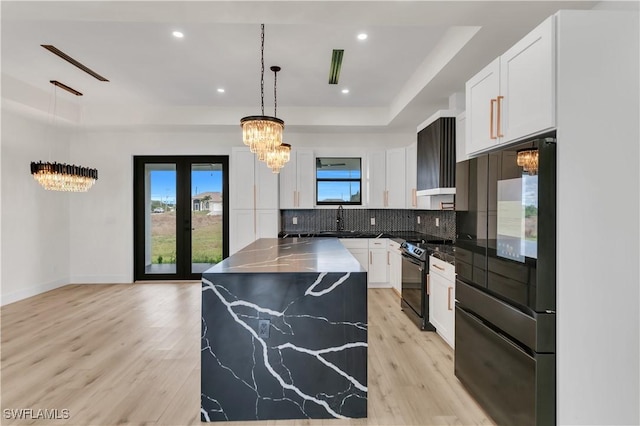 kitchen featuring a raised ceiling, white cabinetry, french doors, and black appliances