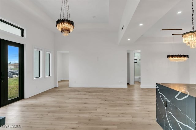 interior space featuring a tray ceiling, recessed lighting, light wood-style floors, and an inviting chandelier