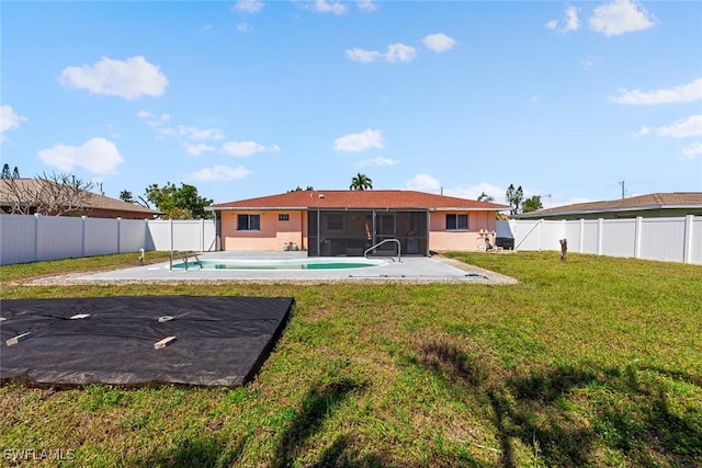 back of property with a fenced in pool, a sunroom, a yard, a fenced backyard, and a patio area