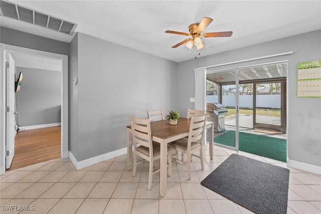 dining space with light tile patterned floors, visible vents, baseboards, and ceiling fan