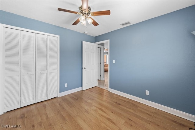 unfurnished bedroom with visible vents, baseboards, wood finished floors, a closet, and a ceiling fan