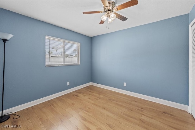 unfurnished room featuring baseboards, light wood-style floors, and ceiling fan