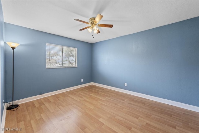 unfurnished room with wood finished floors, baseboards, and ceiling fan