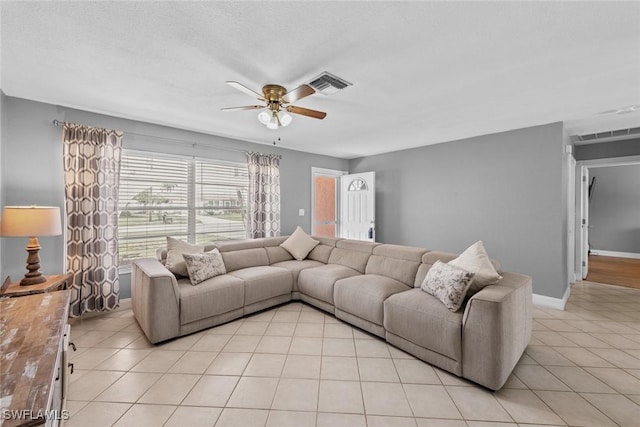 living room with light tile patterned flooring, visible vents, and ceiling fan